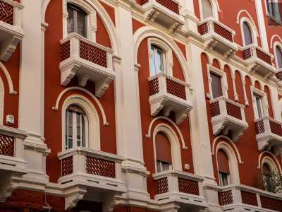...mostra oggi un intenso prospetto rosso carminio dove spiccano bianche finestre ad arco con motivi geometrici e vegetali, colonnine pensili e merlature